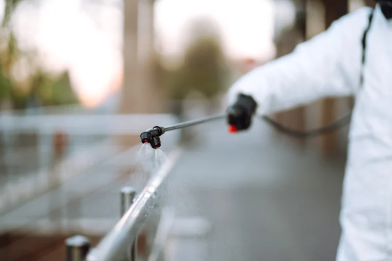 worker-sanitizing-public-surfaces-with-spray-2026-03-20-00-21-02-utc